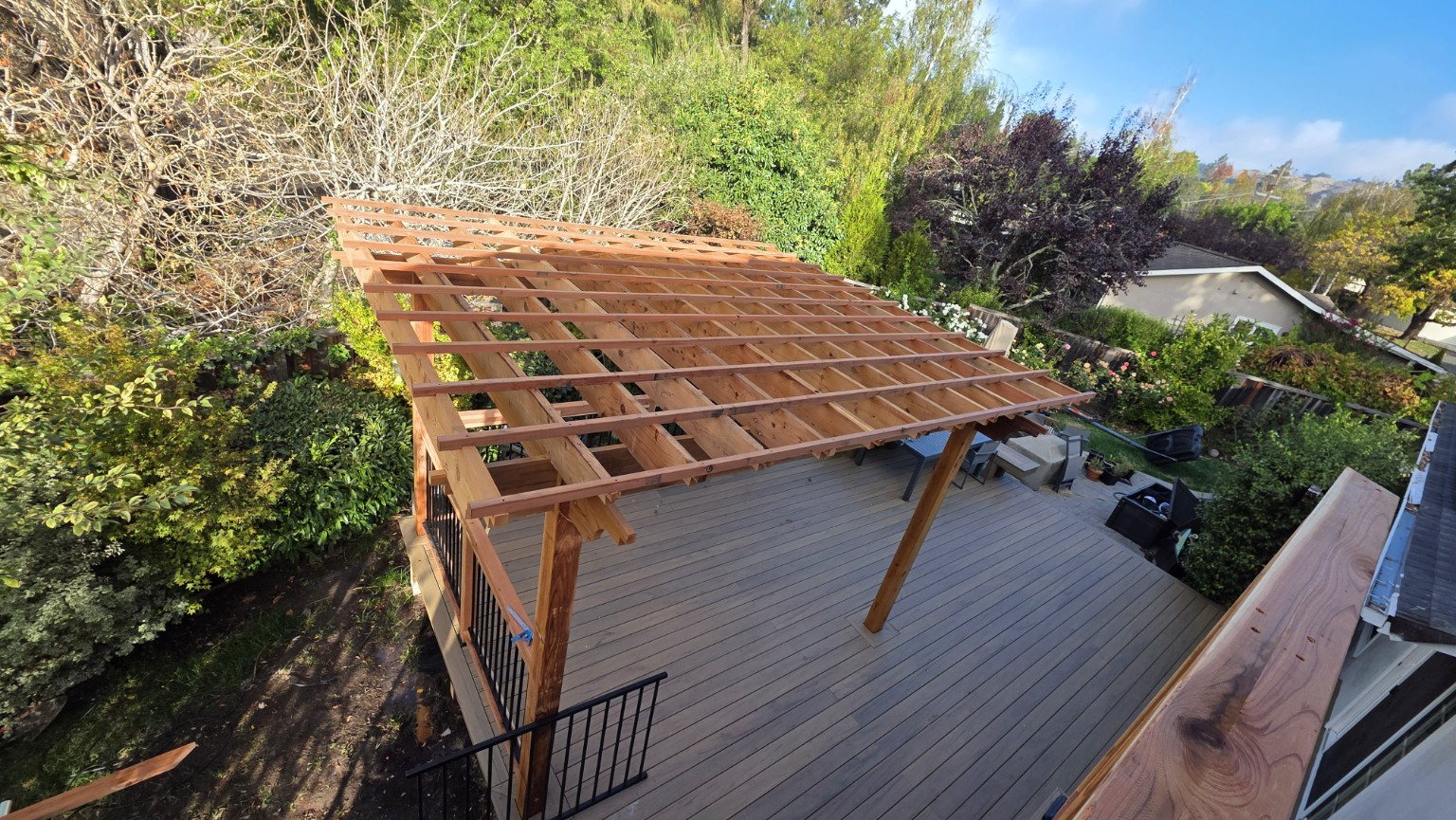 Backyard pergola framing above a finished deck
